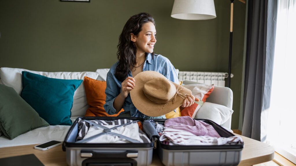 A woman packing for a trip seeing Bible verses for safe travel