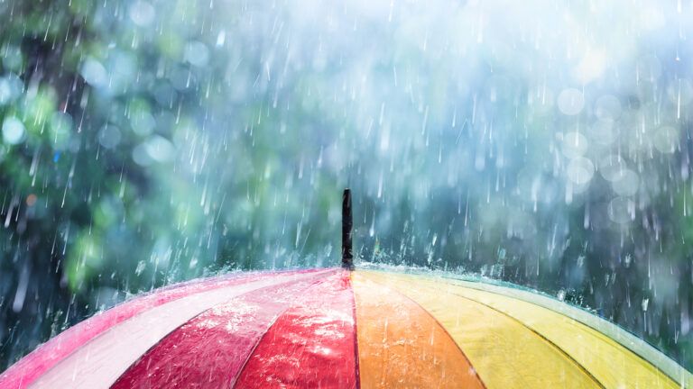 A multicolored umbrella in the rain