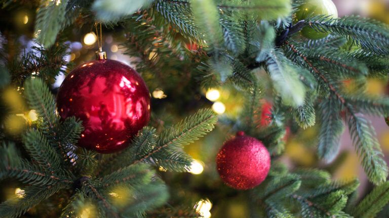 A Christmas tree with shiny red ornaments