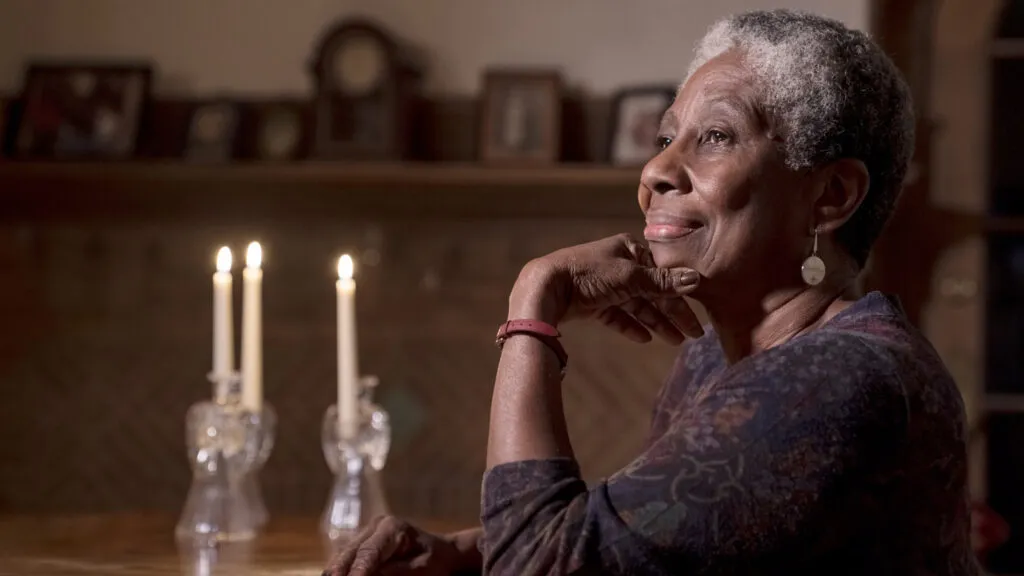 A close-up photo of Tullia Hamilton smiling in her home.