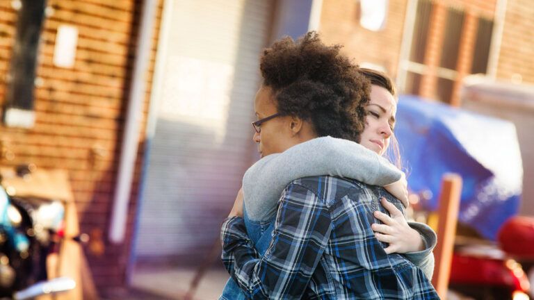 Two friends hug in forgiveness