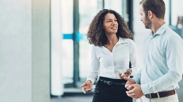 A woman at her workplace talking to a co-worker.