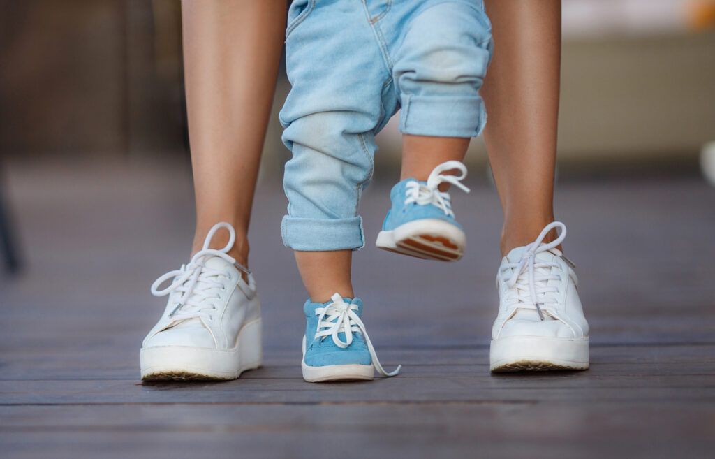 A mom helping her baby walk