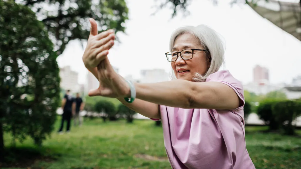 A woman doing Tai chi outdoors.