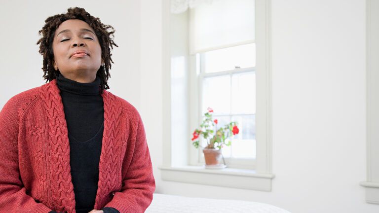 A woman closes her eyes in prayer