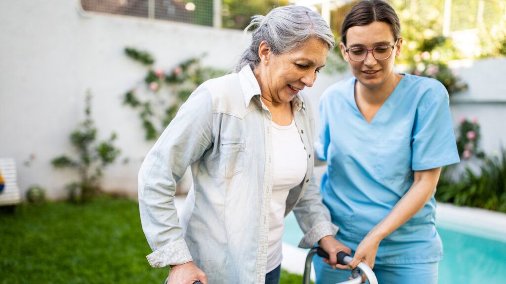 A young caregiver helping a patient.