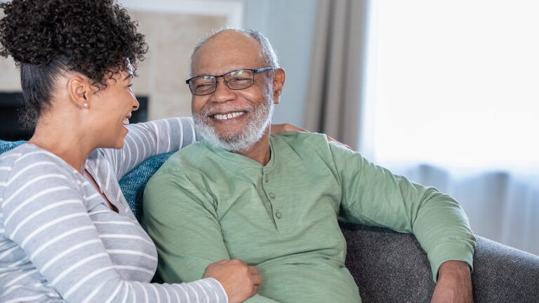 Adult daughter and her senior father smiling