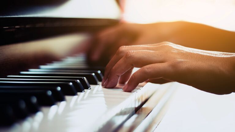 Hands playing a piano