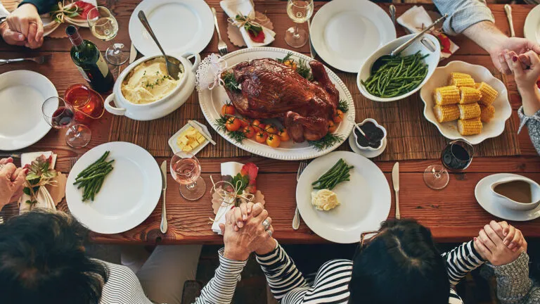 A family prays at the Thanksgiving table