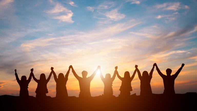 Group of people holding hands and praising God for their ash wednesday reflection