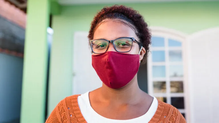 A woman wearing a mask; Getty Images