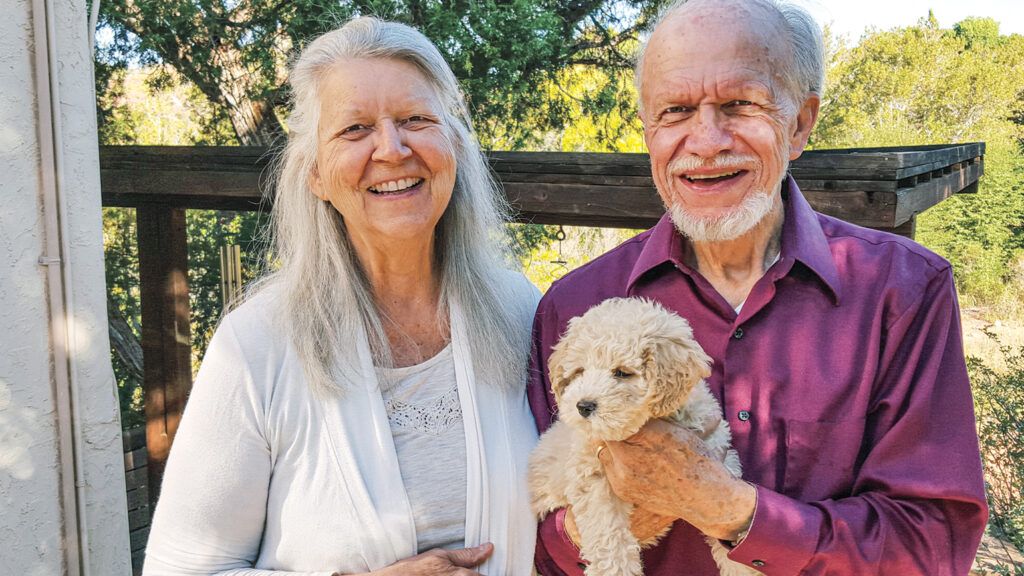 Beth and Ross pose with Sunny, a petite goldendoodle; Photo courtesy: Beth Kingsley Hawkins