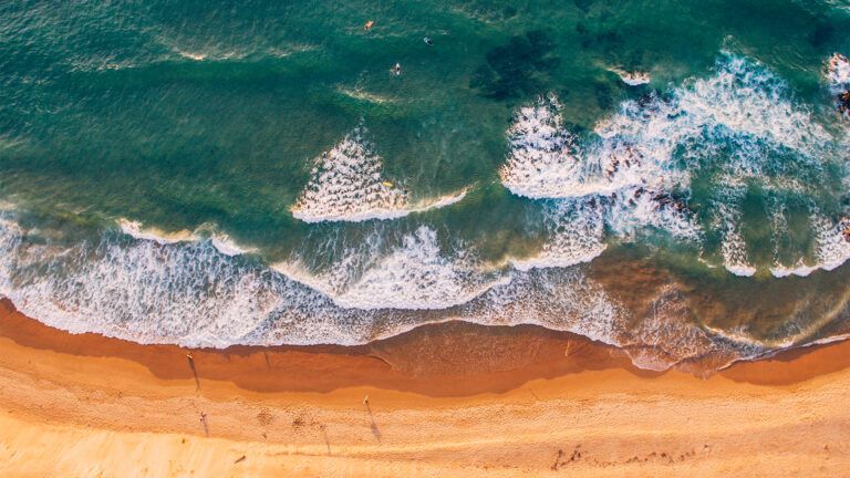 An aerial show of waves lapping on a beach