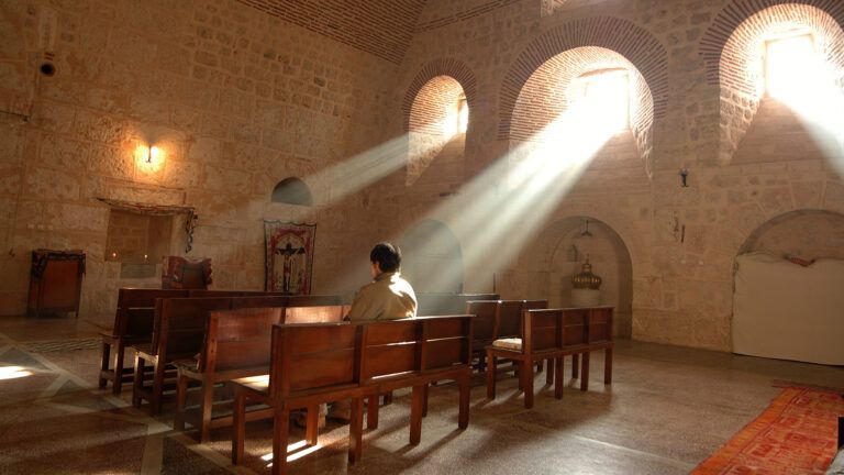 A man sits alone in a church