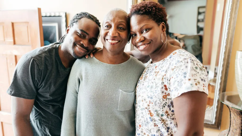 A woman in her golden years with her adult daughter and son; Getty Images