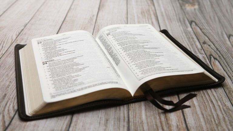 An open Bible rests on a wooden table