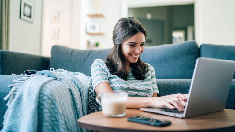 Young woman smiling at her laptop