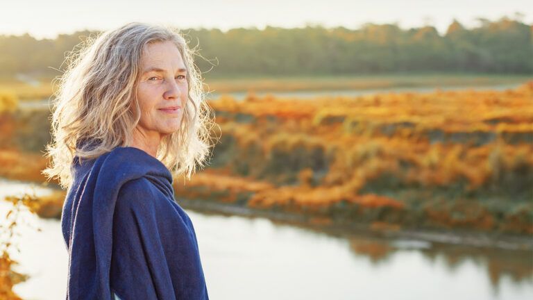 Senior woman standing by a lake