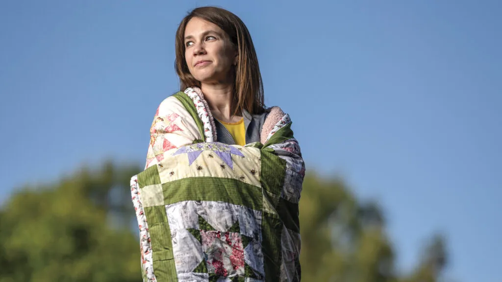 Valerie and her mothers quilt; Photo credit: Michael A. Schwarz