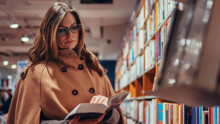 Woman reading a book in a library