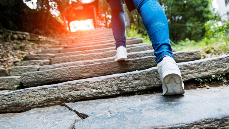 A woman climbs a steep set of steps