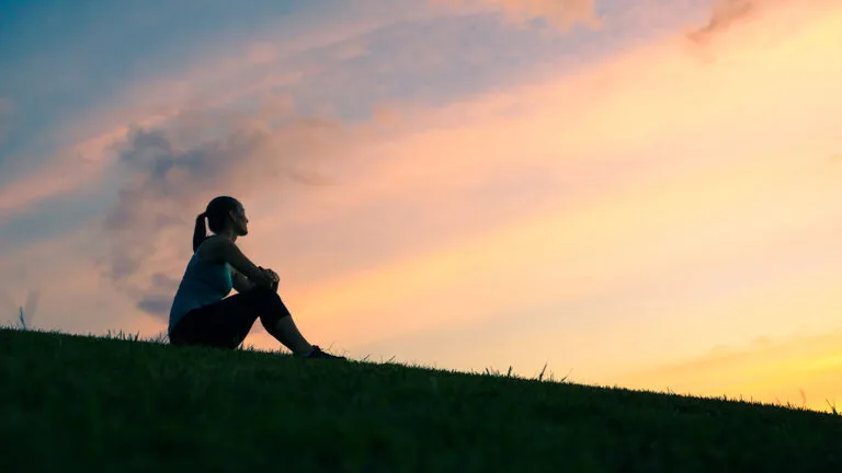 A woman greets the sunrise