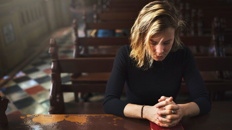 A woman prays alone in church