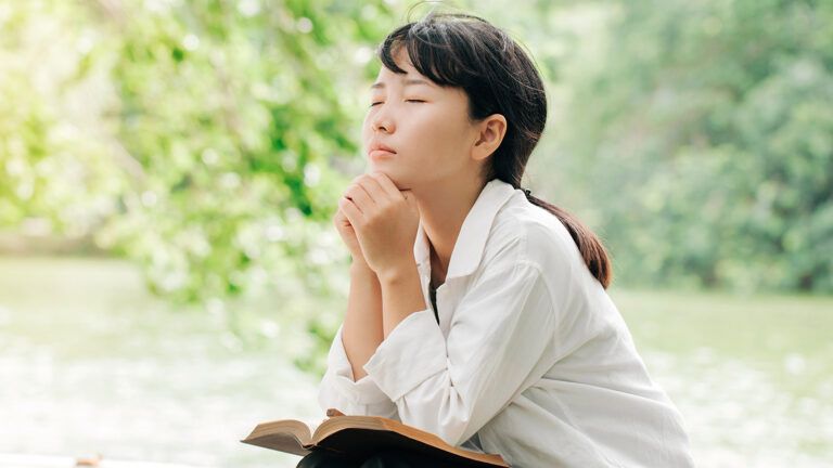 A woman prays ouf of doors