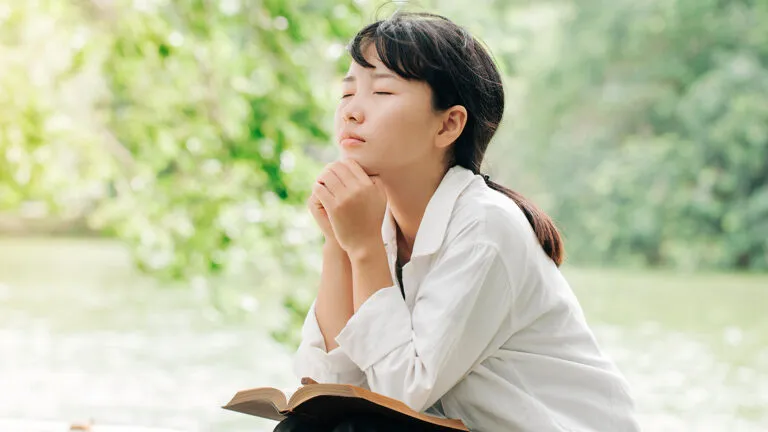 A woman prays ouf of doors