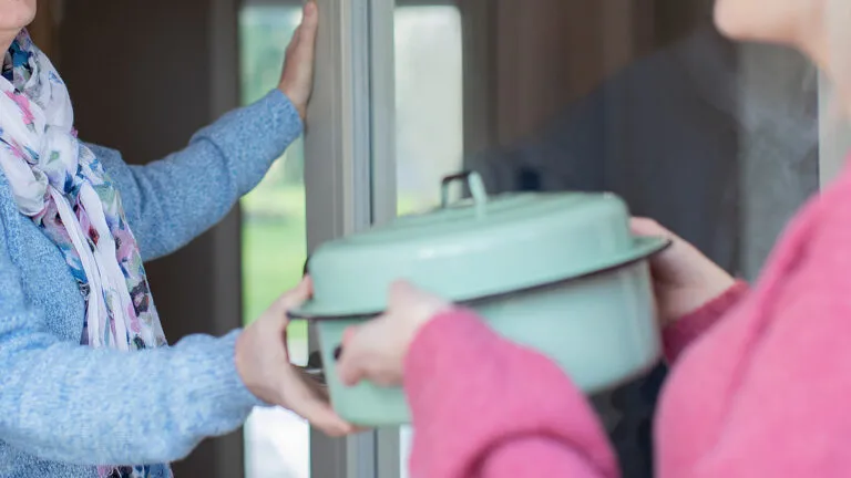 A friend brings a caregiver a casserole