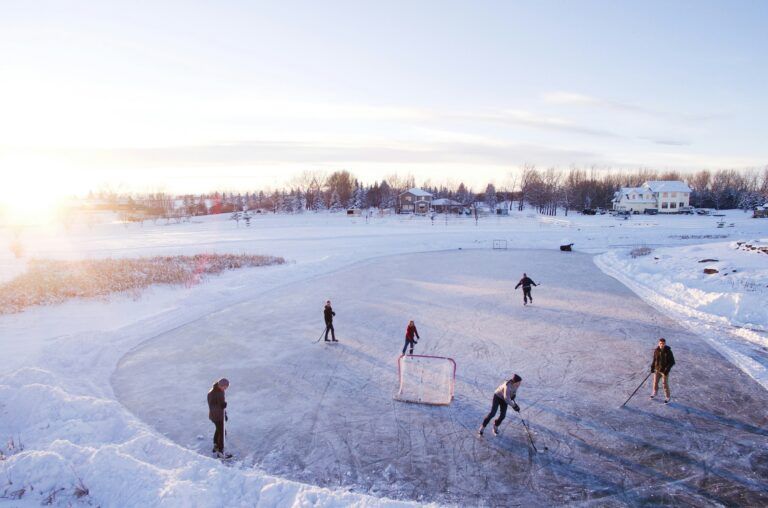 Group of people playing outdoor hockey in winter.