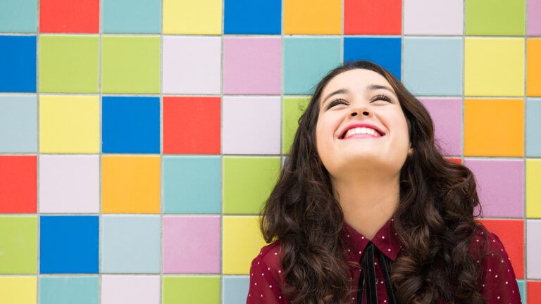 A young woman looks upward, smiling