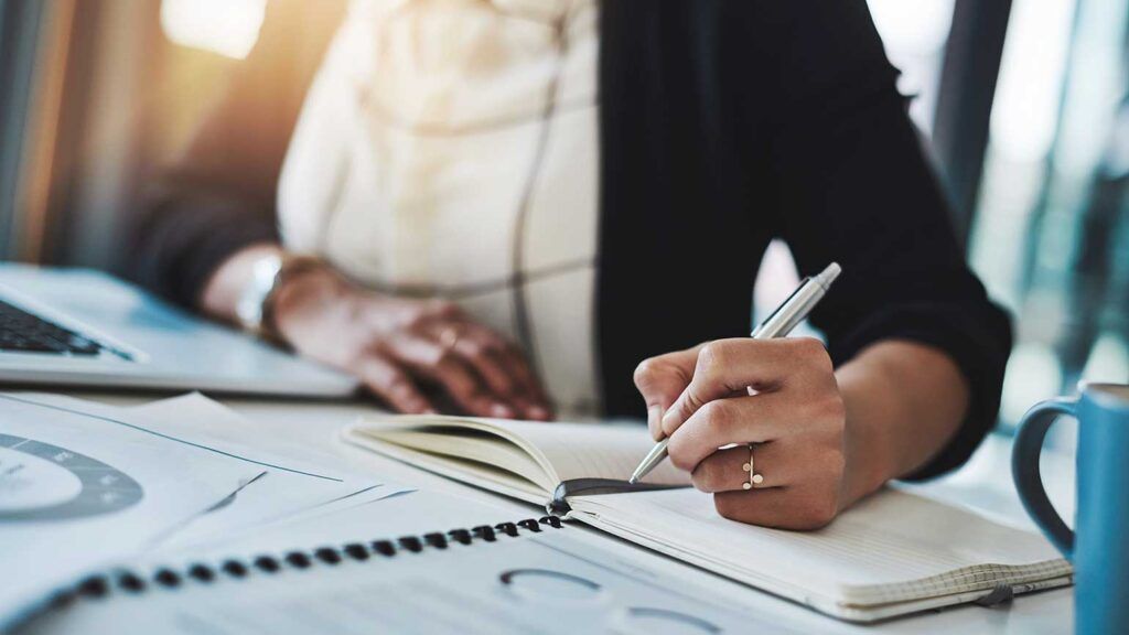 A woman writes in her daily planner