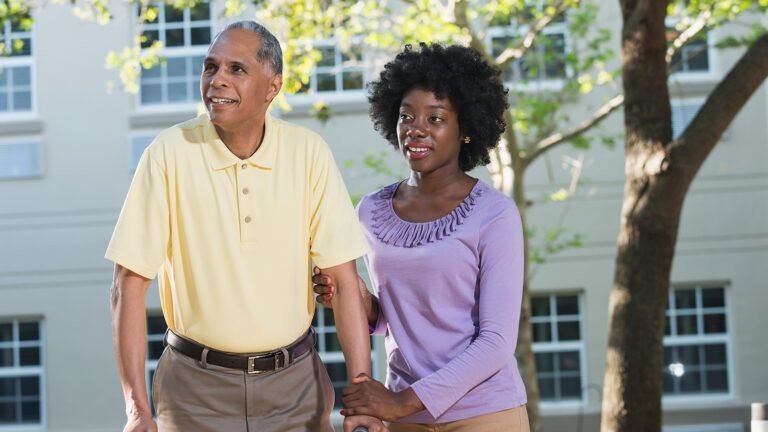 Daughter walking with her senior father