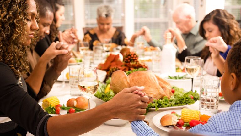 Family saying grace at dinner