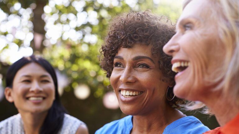 Three female friends smiling