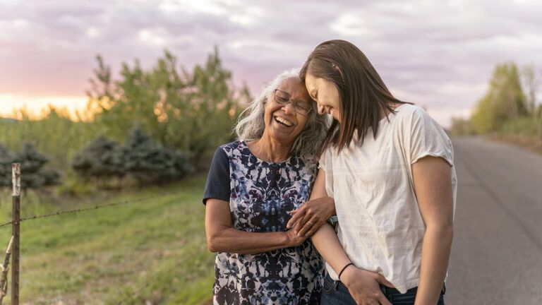 Adult daughter and senior mother outdoors