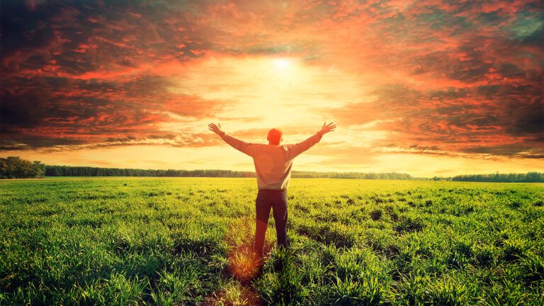 Man lifting arms toward the sunlight