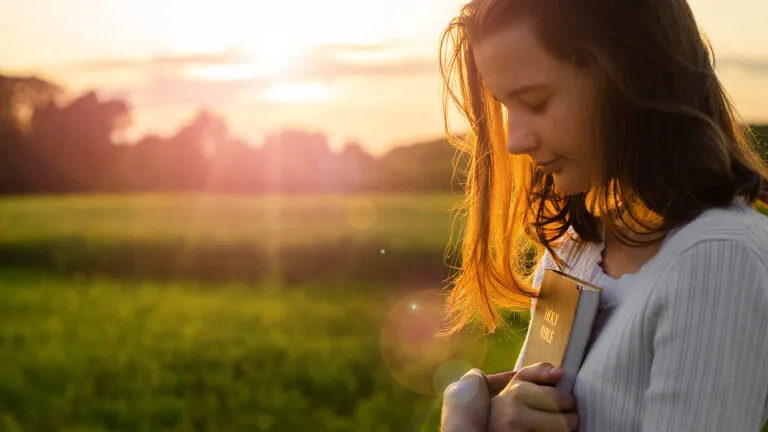 A woman prays at sunrise