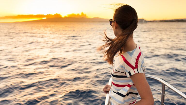 A woman stands at the bow of a boat