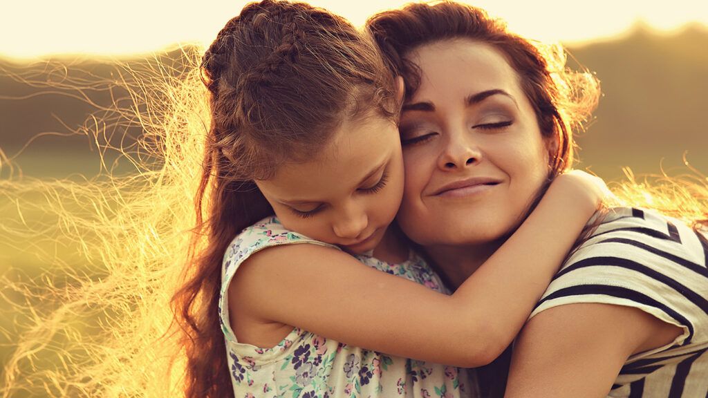 Mom hugging young daughter during Lenten season; Getty Images