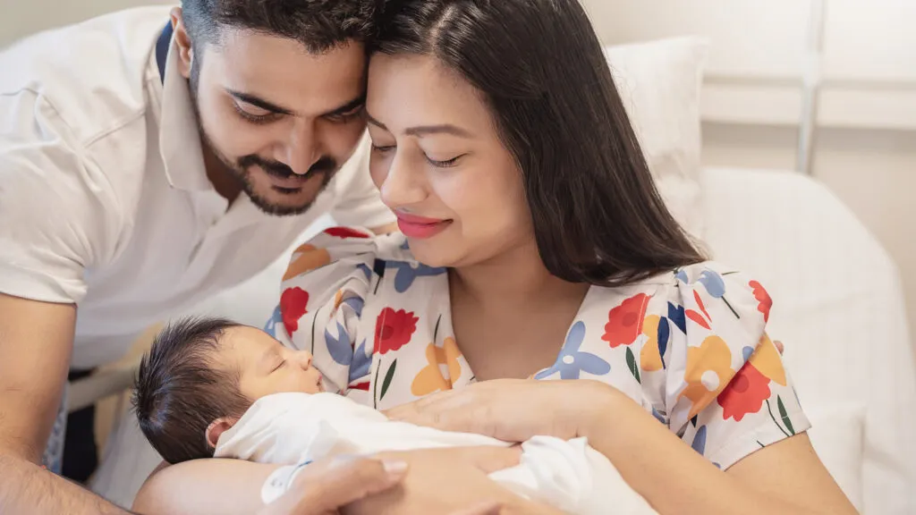 New parents with their newborn in the hospital.