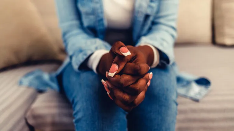 A woman prays in a waiting room; Getty Images