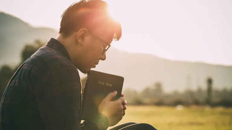 A man prays, Bible in hand, during Lent; Getty Images