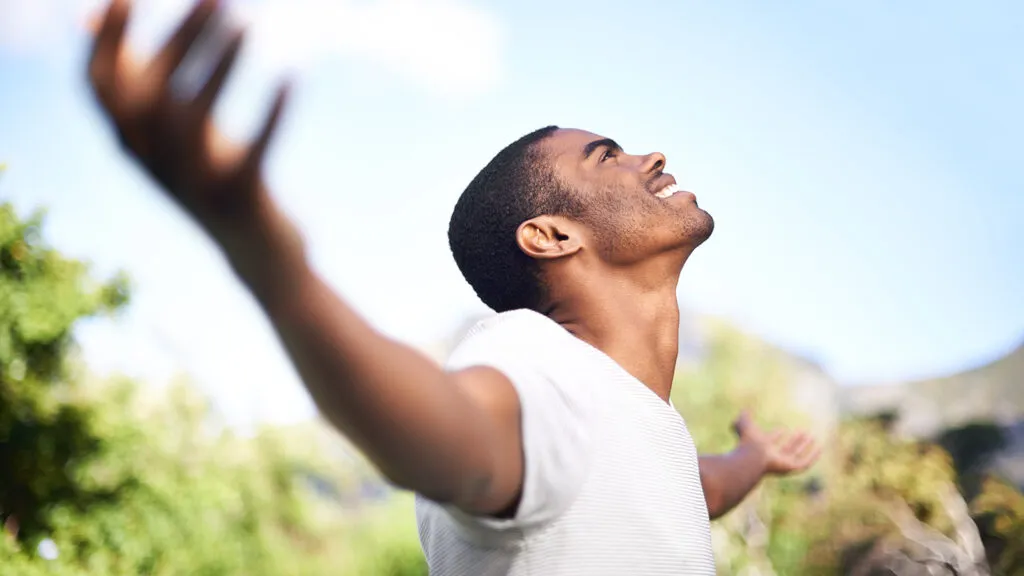 Young man looking up towards the sky during his Lenten journey; Getty Images