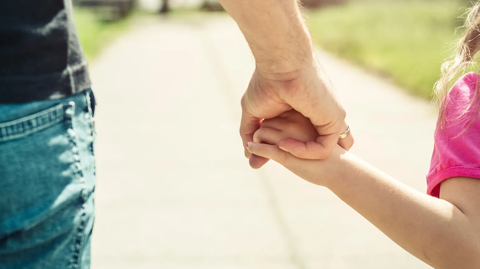 A father holds his child's hand